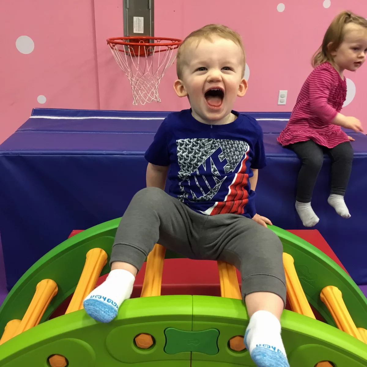 A little boy sitting at the table with his peers enjoying Romp n' Roll's toddler classes.