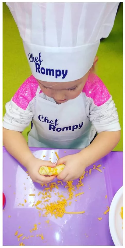 A little red head boy enjoying Romp n' Roll's cooking class.