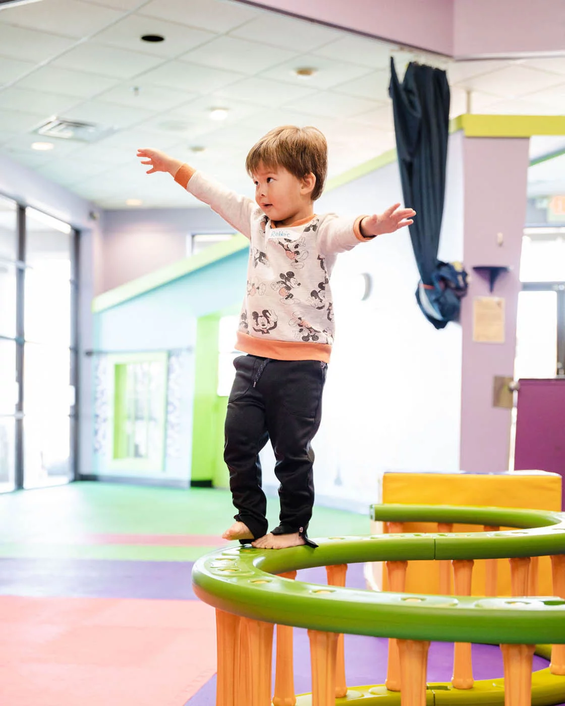 A kid balancing on our gym equipment - join our kids gym franchise at Romp n' Roll.