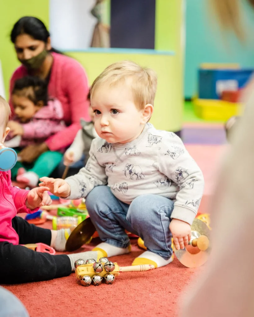 A boy playing with age-appropriate toys and other children at Romp n' Roll's indoor playground franchise.