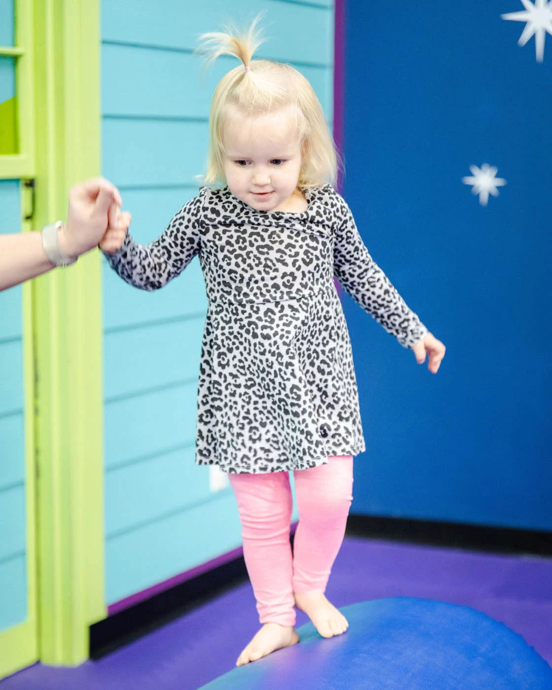 Romp n' Roll little girl playing on gym euqipment at our winter camps.