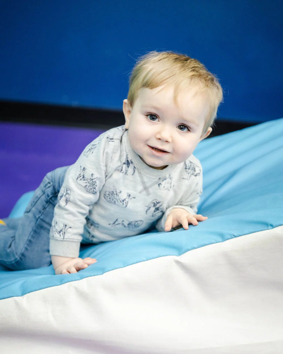 A baby boy taking advandage of Romp n' Roll's baby gym.