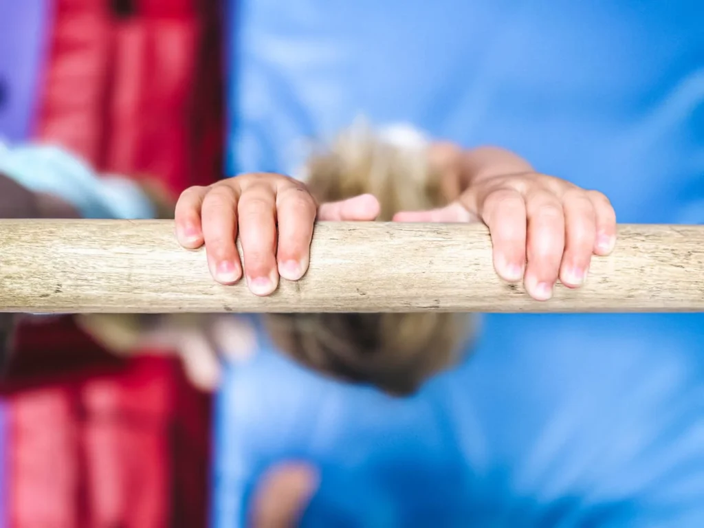 A kid on our kid-safe tumbling bar at Romp n' Roll - our indoor playground franchise opportunity.