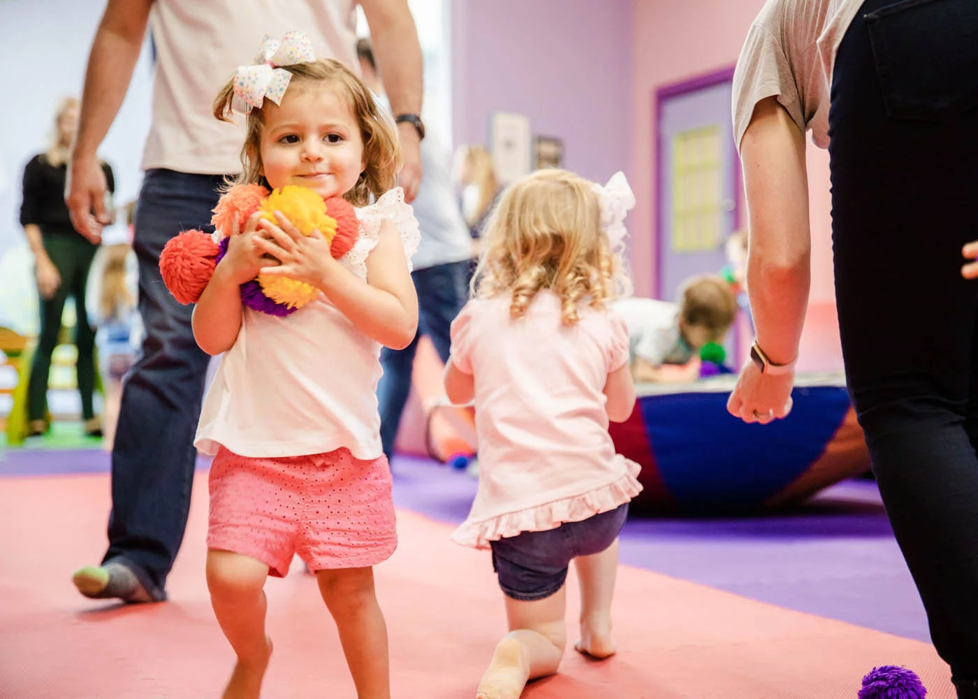 Kids playing with puffy balls in Romp n' Roll's gym, contact us today for charitable giving options.