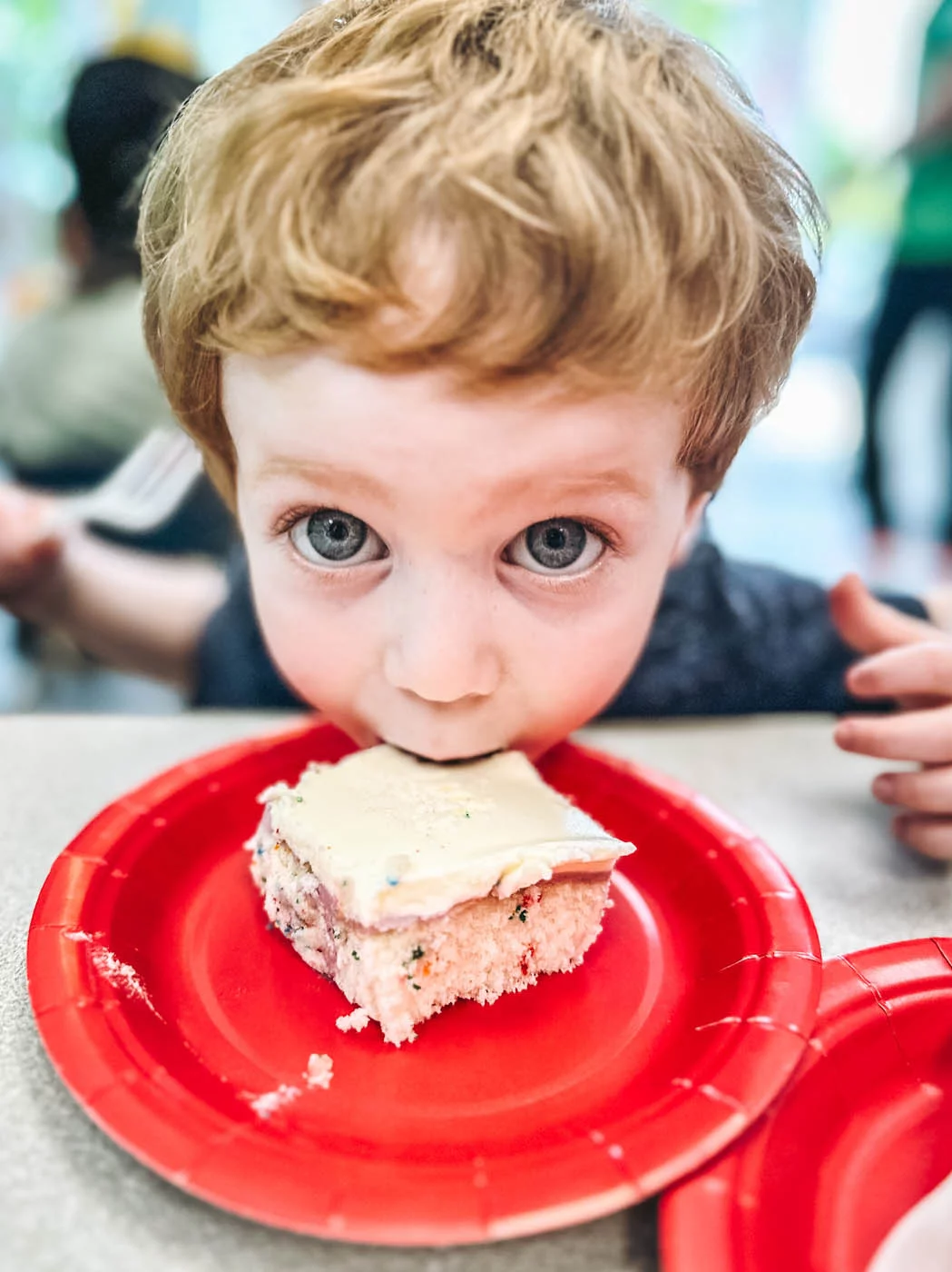 A child at a Romp n' Roll children's party eating cake.