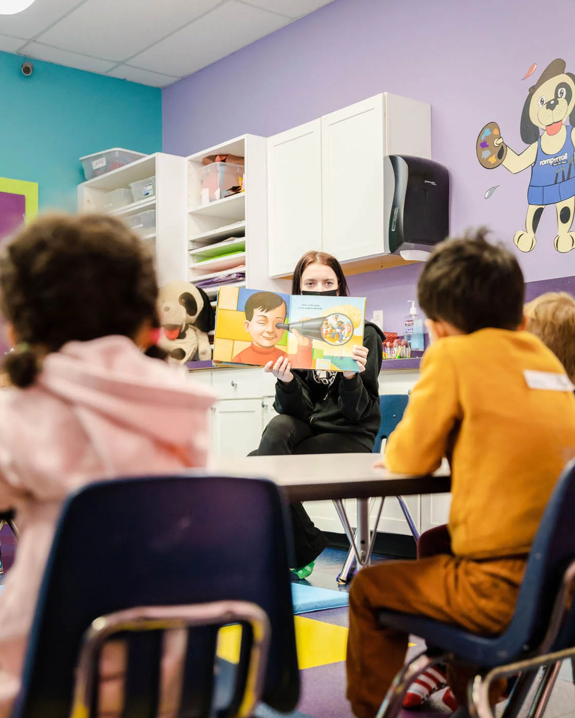 Romp n' Roll instructor reading and teaching kids at our instructor-led classes